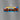 Image of a Little Debbie Cosmic® Brownies carton magnet, measuring 3 inches wide and 1 inch tall. The magnet features a colorful design with the Little Debbie logo, images of square brownies topped with rainbow-colored chocolate chip candies, and the vibrant 'Cosmic® Brownies with Chocolate Chip Candy' text. The background of the carton is adorned with bright, multicolored lights, creating a festive, cosmic effect.