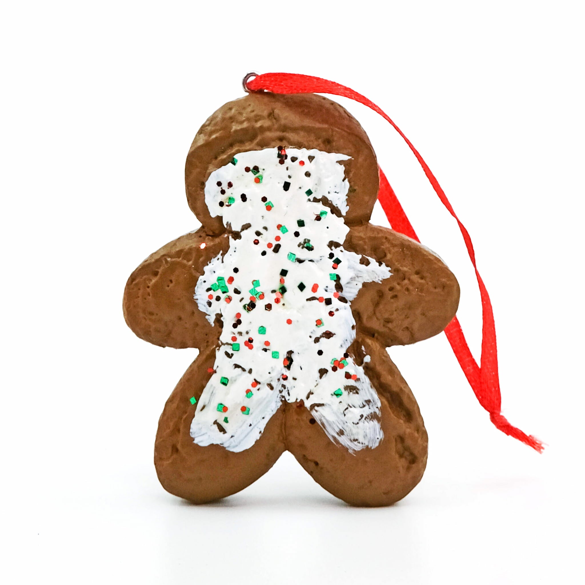 Little Debbie Gingerbread Cookie Ornament shaped like a gingerbread cookie with white icing details and festive red and green sprinkles with a red ribbon against a white background.