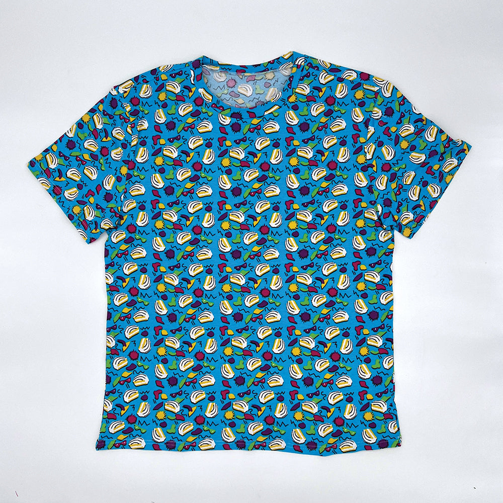 Front view of a Little Debbie® 90s Retro Zebra Cakes T-shirt. The shirt is predominantly blue with a vibrant pattern of iconic Zebra Cakes, along with playful yellow, green, and red shapes, squiggly lines and dots reminiscent of the 90s design aesthetics. The T-shirt has a round neckline and short sleeves.