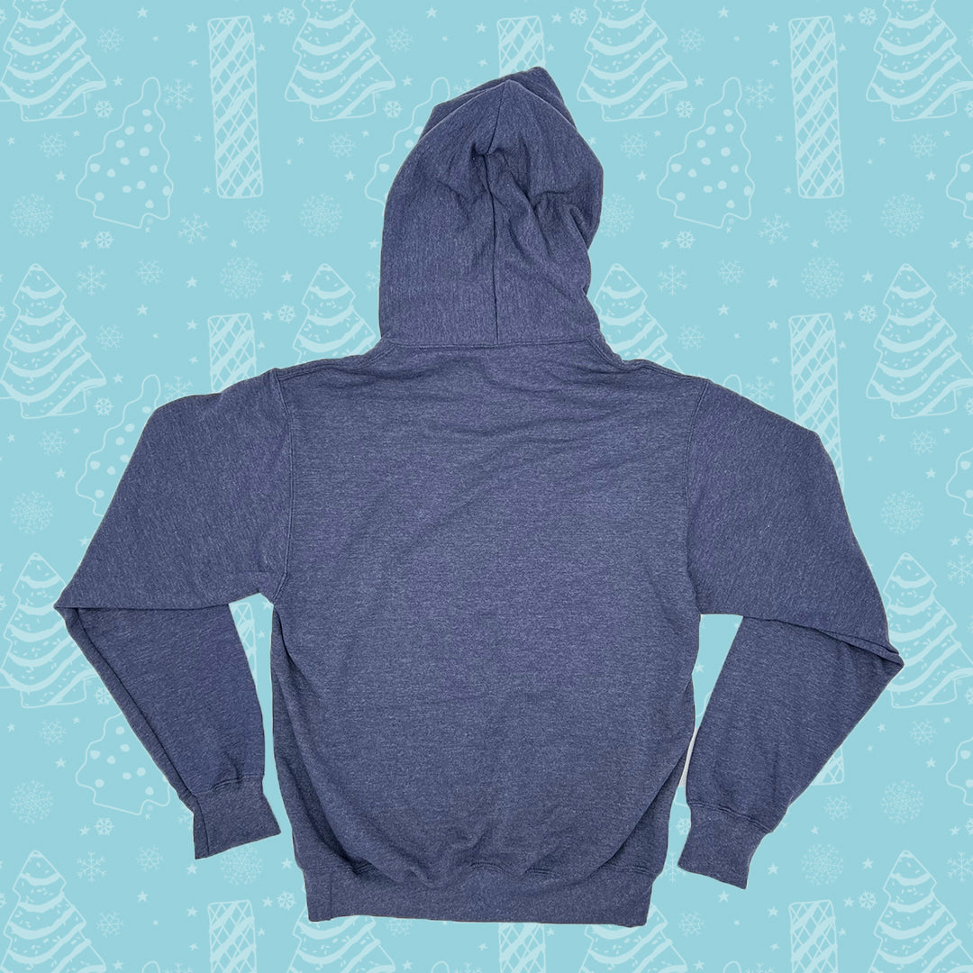 Back view of a blue Little Debbie Unwrap a smile hoodie displayed on a white background. The hoodie is shown with the hood up, and has long sleeves with ribbed cuffs. The back of the hoodie is plain without any visible designs or text. It's set against a light blue background patterned with white illustrations of Christmas Trees Cakes, Christmas Tree Brownies, snowflakes, and other winter motifs.