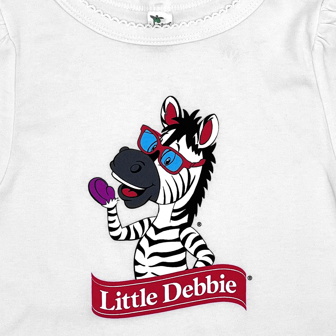 Detail view of a white Little Debbie toddler shirt featuring Zain the Zebra™ waving. The scalloped detail on the neck is in view.