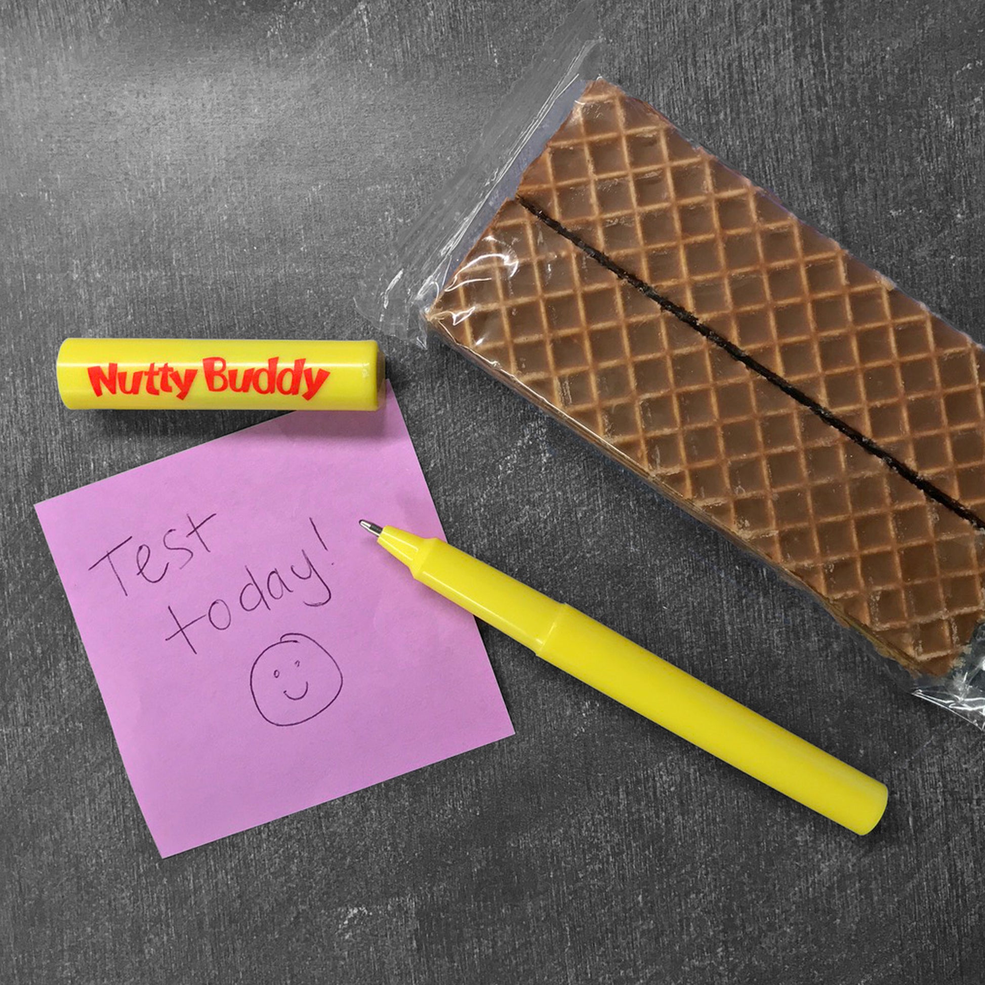 Nutty Buddy® acrylic pen next to a sticky note and a Nutty Buddy® wafer bar snack. 